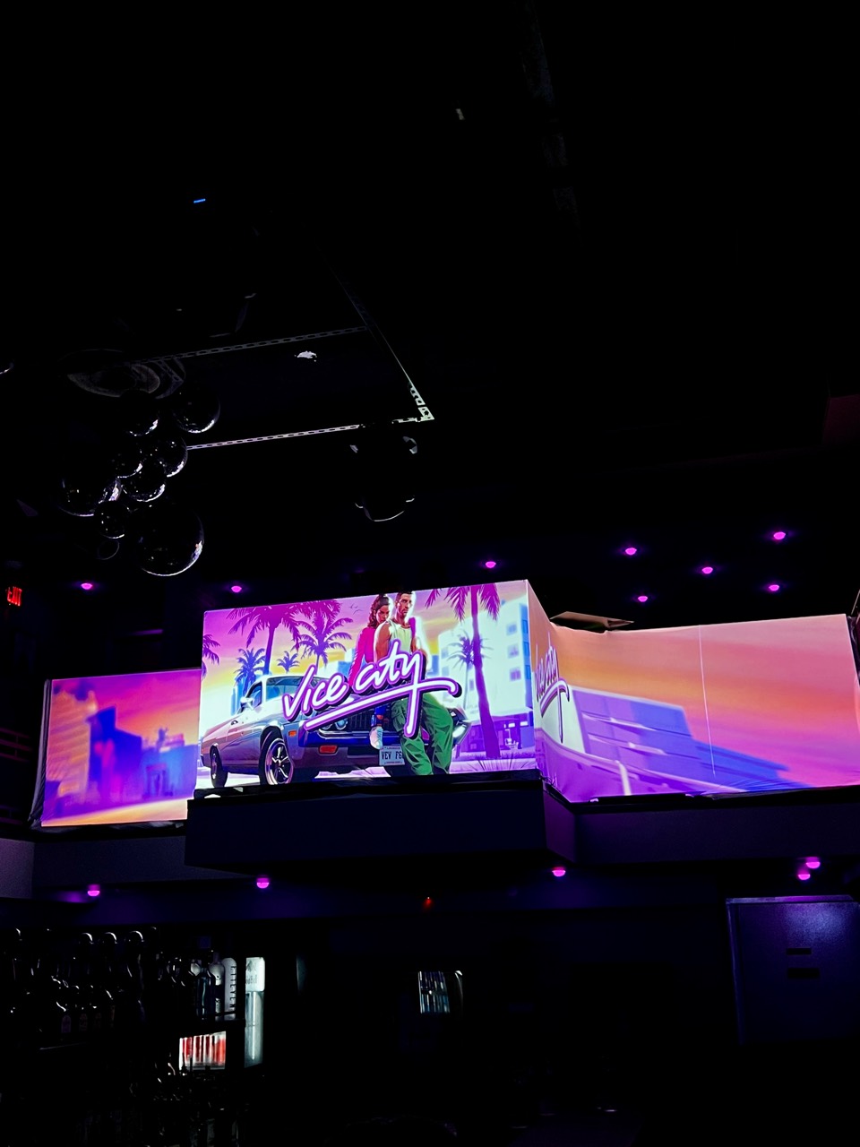 Vice City visuals wrapping a multi-panel bar installation, viewed from below